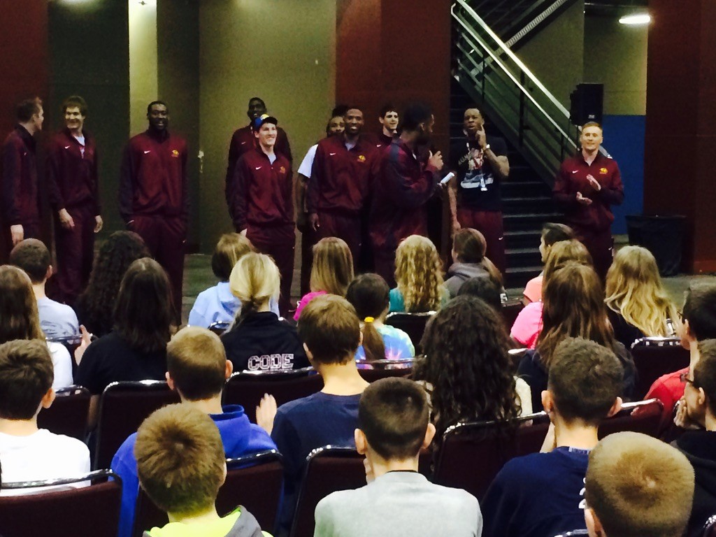College basketball team speaking with young athletes